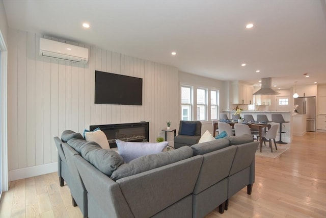 57 Garrison Ave Unit 57, Somerville, MA 02144 - living area with a wall unit AC, light wood-style floors, recessed lighting, and a glass covered fireplace