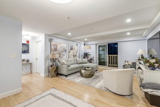 living room with baseboards, light wood finished floors, and recessed lighting