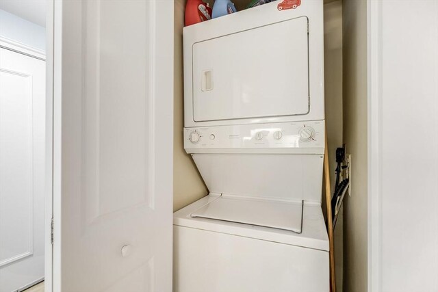 laundry room with stacked washer and dryer and laundry area