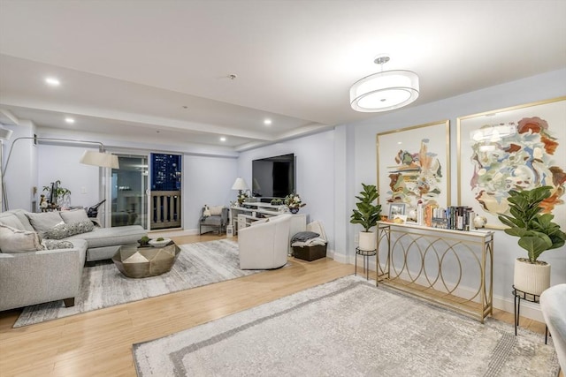 living area featuring baseboards, wood finished floors, and recessed lighting