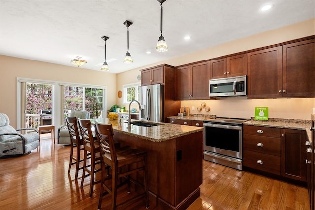 16 Boatwrights Loop, Plymouth, MA 02360 - kitchen with a kitchen bar, wood-type flooring, a sink, stainless steel appliances, and light stone countertops