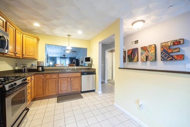 65 Bliss Ave Unit 4, Attleboro, MA 02703 - kitchen featuring stainless steel appliances, dark countertops, light tile patterned flooring, decorative light fixtures, and brown cabinets
