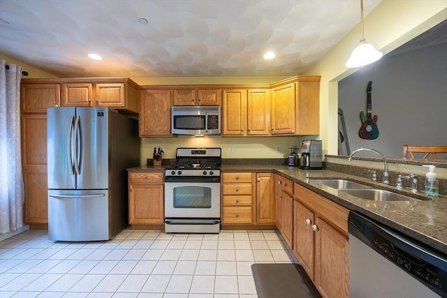 65 Bliss Ave Unit 4, Attleboro, MA 02703 - kitchen featuring appliances with stainless steel finishes, light tile patterned floors, dark stone countertops, hanging light fixtures, and brown cabinets