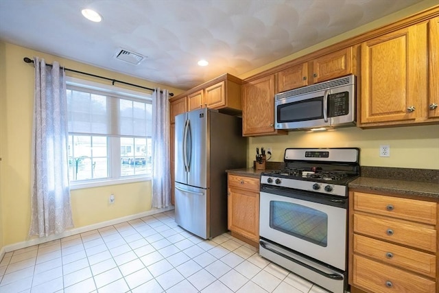 65 Bliss Ave Unit 4, Attleboro, MA 02703 - kitchen with appliances with stainless steel finishes, dark countertops, brown cabinetry, light tile patterned floors, and recessed lighting