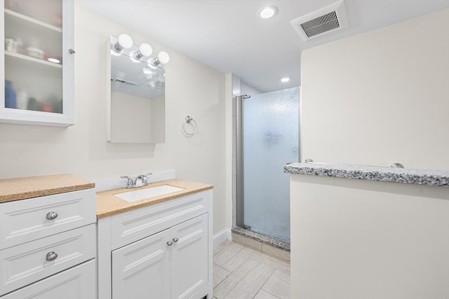 bathroom featuring recessed lighting, visible vents, a shower stall, and vanity