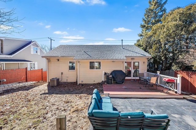 rear view of property featuring roof with shingles, fence, a wooden deck, and central air condition unit