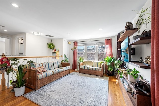 living room with visible vents, wood finished floors, and recessed lighting