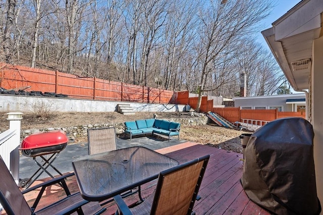 wooden terrace with outdoor dining area, a fenced backyard, outdoor lounge area, and a grill