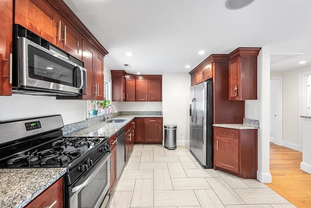 kitchen with stainless steel appliances, recessed lighting, a sink, and light stone counters