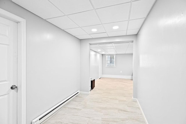 hallway featuring a drop ceiling and a baseboard radiator