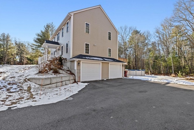 view of snowy exterior with a garage