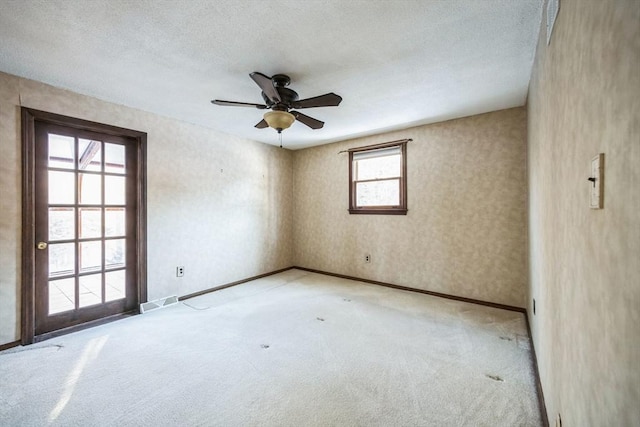 empty room featuring ceiling fan, light carpet, and a healthy amount of sunlight