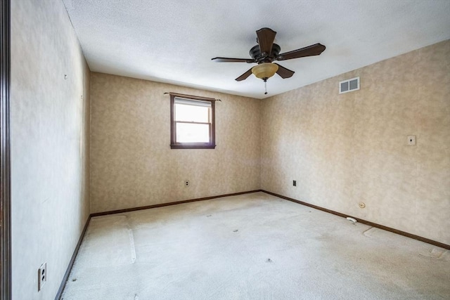 empty room with ceiling fan and a textured ceiling