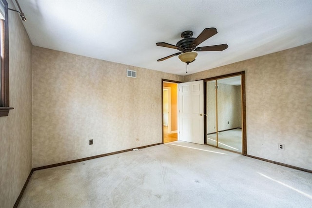 empty room with ceiling fan and carpet