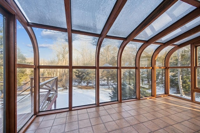 unfurnished sunroom featuring beamed ceiling