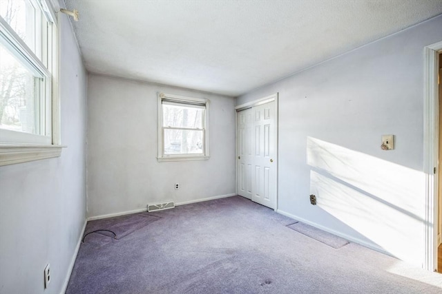 unfurnished bedroom with a closet and carpet