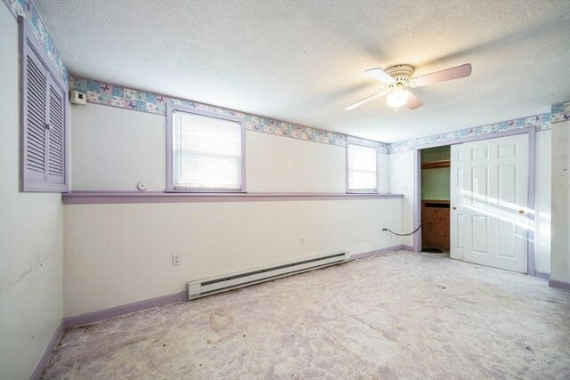 unfurnished bedroom with ceiling fan, a closet, multiple windows, and a baseboard heating unit