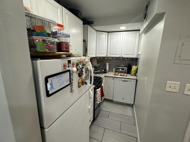 kitchen with white appliances, tasteful backsplash, and white cabinetry