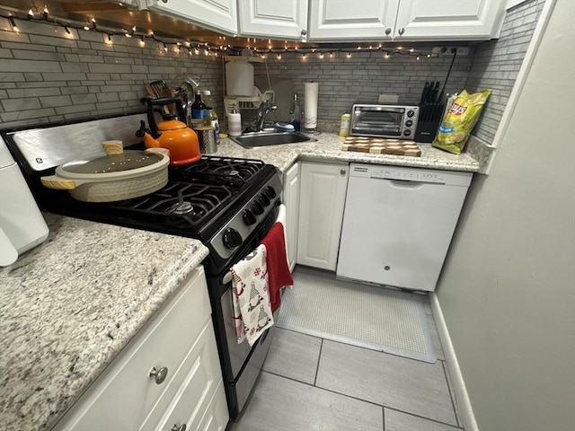 kitchen with decorative backsplash, white dishwasher, white cabinetry, and stainless steel gas range oven