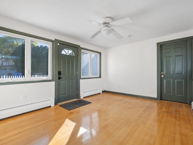 foyer featuring ceiling fan, a baseboard heating unit, baseboards, and light wood-type flooring