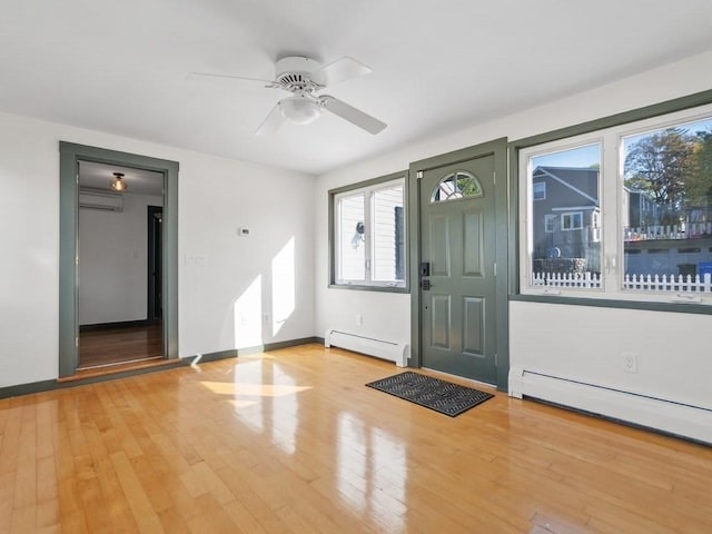 foyer featuring an AC wall unit, a ceiling fan, light wood-style floors, and baseboard heating