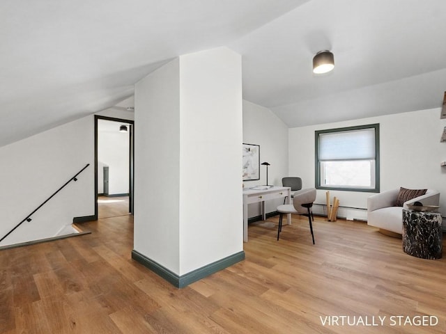 sitting room featuring light wood-type flooring, baseboards, a baseboard heating unit, and vaulted ceiling