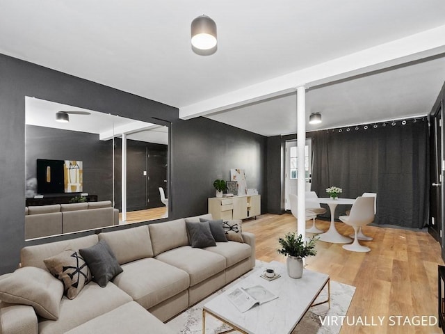 living room with beamed ceiling, decorative columns, and wood finished floors