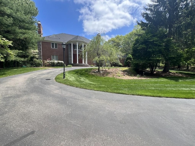 34 Grandhill Dr, Dover, MA 02030 - greek revival house featuring curved driveway, a front yard, and a chimney