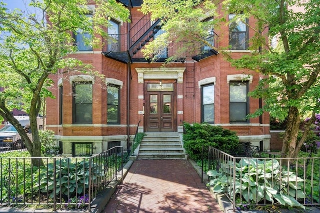 view of exterior entry with french doors and brick siding