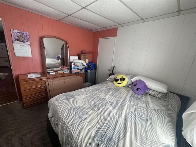 bedroom featuring wooden walls and carpet
