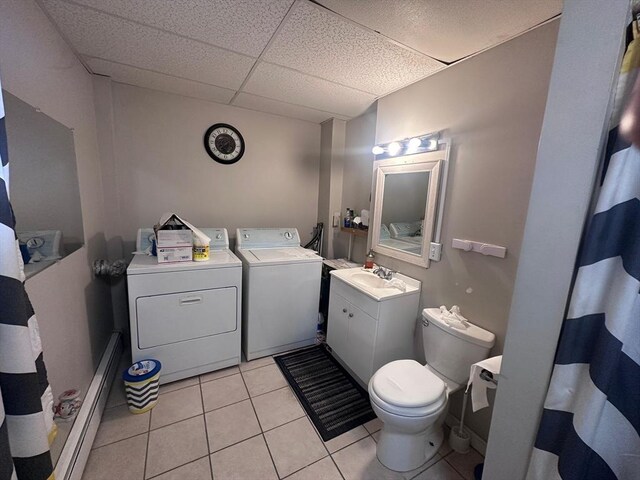 bathroom featuring tile patterned floors, a drop ceiling, toilet, vanity, and washer and dryer