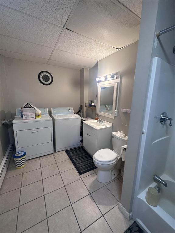 bathroom featuring tile patterned floors, shower / bath combination, toilet, independent washer and dryer, and a paneled ceiling