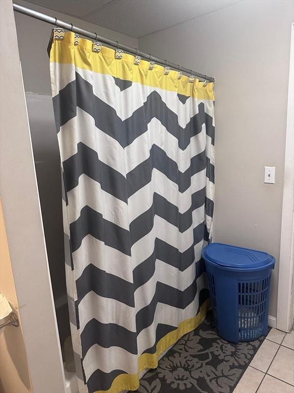 bathroom with a shower with curtain and tile patterned floors