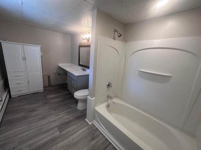 full bath with wood finished floors, vanity, toilet, a paneled ceiling, and bathing tub / shower combination