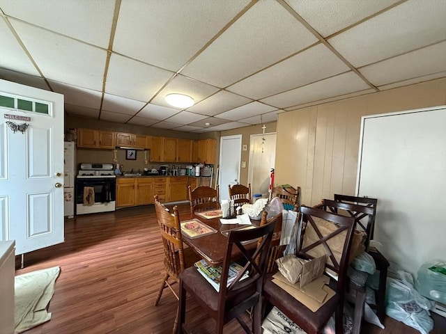 dining area with a paneled ceiling and dark wood-style floors
