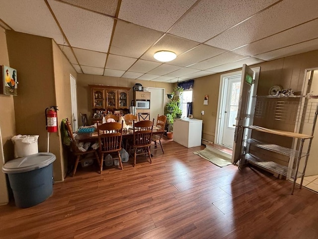 dining area with wood finished floors and a paneled ceiling