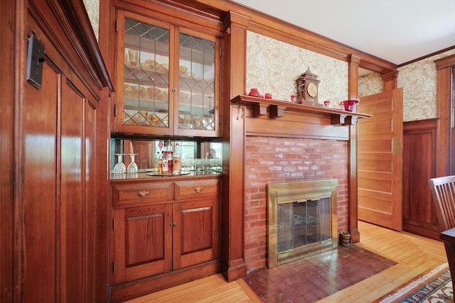 95 Glendale Rd, Sharon, MA 02067 - bar area featuring wainscoting, a brick fireplace, crown molding, light wood-type flooring, and wallpapered walls