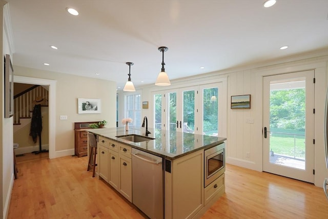 95 Glendale Rd, Sharon, MA 02067 - kitchen with appliances with stainless steel finishes, dark stone countertops, decorative light fixtures, a center island with sink, and light wood-style flooring