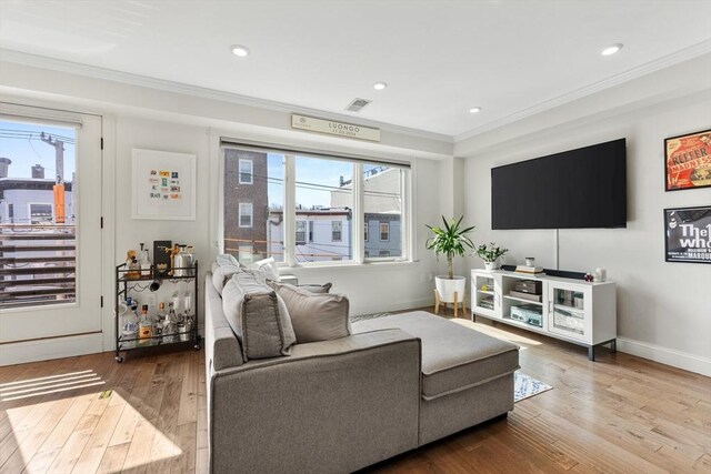 living area with recessed lighting, ornamental molding, baseboards, hardwood / wood-style flooring, and visible vents