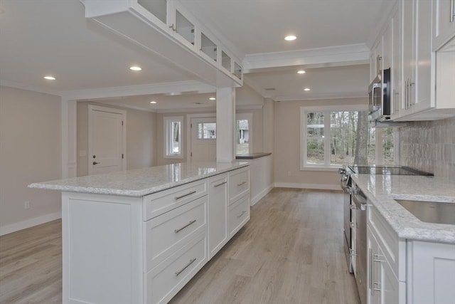 kitchen with tasteful backsplash, stainless steel appliances, crown molding, and light wood-style flooring