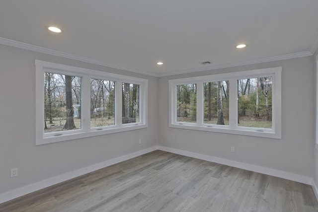 unfurnished room with recessed lighting, crown molding, baseboards, and wood finished floors