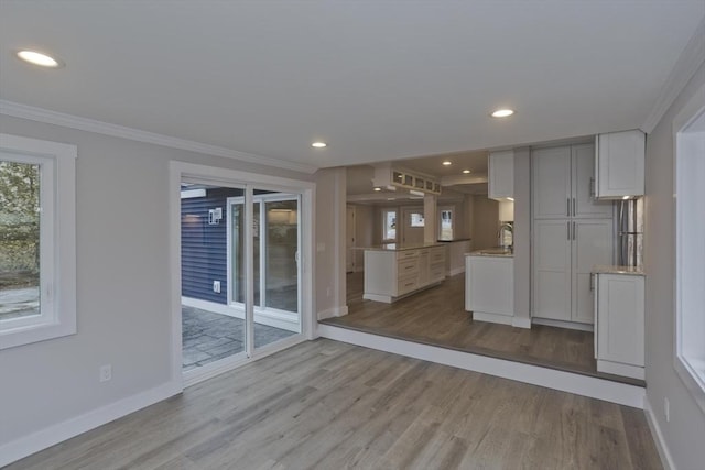 kitchen with ornamental molding, recessed lighting, wood finished floors, and baseboards