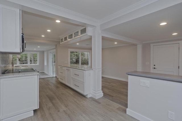 kitchen with light wood finished floors, white cabinetry, and a healthy amount of sunlight