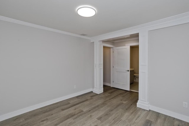 unfurnished room with baseboards, wood finished floors, and crown molding