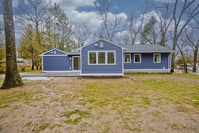 rear view of property with a lawn