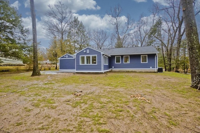 rear view of house featuring a yard and central AC unit