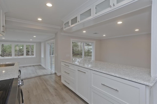 kitchen featuring light stone counters, light wood-style flooring, electric range, white cabinets, and crown molding