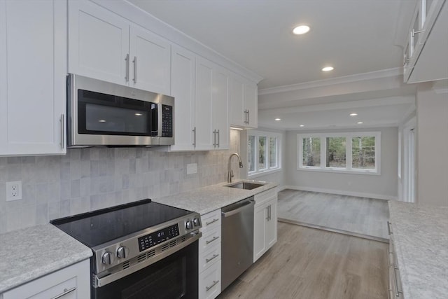 kitchen with open floor plan, light countertops, appliances with stainless steel finishes, and a sink