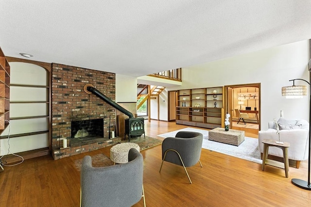 26 Ashfield Ln, South Hadley, MA 01075 - living area featuring wood finished floors, stairway, a textured ceiling, and a brick fireplace