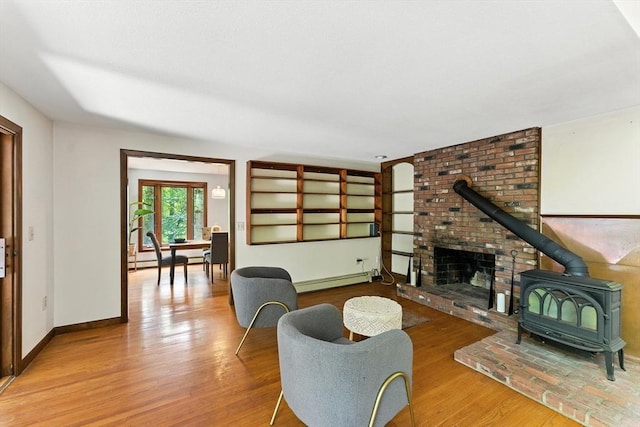 26 Ashfield Ln, South Hadley, MA 01075 - living area with a wood stove, wood finished floors, and a baseboard radiator